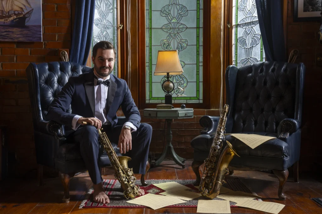 Lorenzo Ferrero seated with saxophones and manuscripts for Voyage